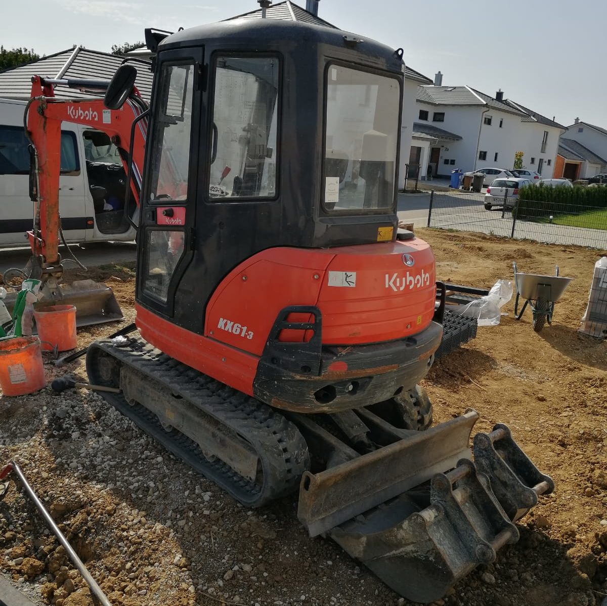 Minibagger Kubota KX61-3 mit abgesetzter Schaufel auf einer Baustelle