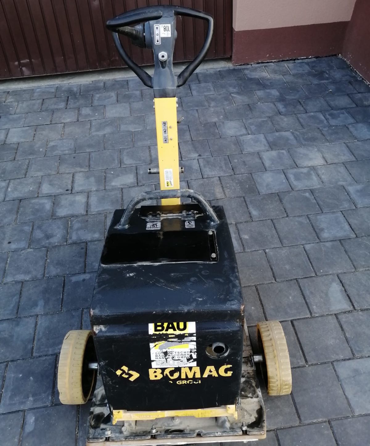 Gelb-schwarze Bomag-Rüttelplatte mit aufrechtem Griff